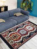 Multi-functional Armenian folk art rug used as a floor rug carpet near a modern fabric light blue sofa. Armenian traditional rug with geometric ornaments in navy blue and red on a living room floor.