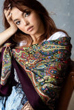 asian style girl with ginger hair wearing a large shawl around her shoulders and seating on the sofa