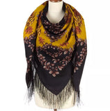 Wrapping women scarf with floral pattern and fringes made of natural merino wool on a mannequin against a white background