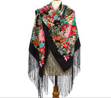 An elegant, very large winter shawl made of natural merino wool, detailed with a black fringed border and a lush vintage arrangement of blooming peonies and colorful field flowers.