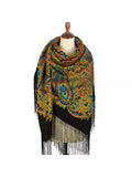 Colorful paisley patterned scarf with fringes on a mannequin against a white background