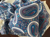 Blue and white paisley patterned shawl on a wooden surface