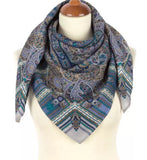 Blue paisley patterned blue and gray woolen scarf without fringe on a mannequin with a white background