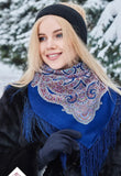 Woman wearing a blue scarf with intricate patterns in a snowy outdoor setting