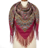 Colorful patterned woolen wrapping scarf with fringes on a mannequin against a white background