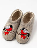Pair of woolen Slavic slippers with bird and berry design on a white background