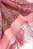 Pink merino wool scarf with fringes on a patterned fabric background