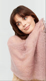 Knitted dusty rose pashmina shawl wrapped on a woman's shoulders. A lightweight and warm pashmina warm shawl in a dusty pink hue, styled as an elegant shoulder wrap.