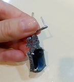 Earring with navy stone and marcasite in vintage style showcasing an English lock in a woman`s hand.