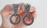 Silver earrings with geometric patterns, displayed on a woman`s hand with white background and Armenian Spirit title.