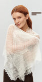 Elegant styling of a lightweight knitted pashmina shawl in ecru draped over a woman's shoulders.