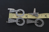 a  photo showing a jewelry set with armenian ethnic ornaments with round, triangle and sun designs near a ruler.