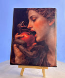 Dark academia style religious artwork panel depicting the temptation in the Garden of Eden. Handmade theological wood plaque with genuine gold leaf accents and dark background details. Fine art printed on a thick wood block with rustic dark edges for home gallery display.
