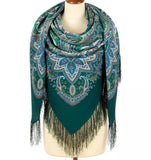 Green paisley scarf with fringes on a mannequin against a white background