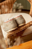 A top-down view of premium handcrafted women's house slippers made from thick, un-dyed cream white sheep wool felt. 