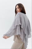 A woman wearing a large body cover warm gray goat down woolen wrap on her shoulders.