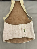 Close-up of the soft, fluffy texture of the 95% natural camel wool fabric used in the back support belt. Side view of a woman adjusting the anatomical wool lumbar support belt with rigid stay bars.
