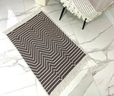 Geometric patterned rug with fringe on a marble floor