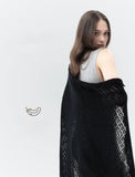 A woman elegantly draping the lightweight gossamer pashmina shawl over her shoulders for a cozy evening out. The soft folds demonstrate how gracefully the square cm fabric falls.
