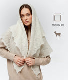 The delicate ivory gossamer pashmina square scarf is shown covering a woman head and shoulders. The lighting beautifully isolates the fine workmanship of the handmade stitches.