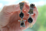 vise versa earrings silver assymetrical earrings with gilded eternity signs. The gemstone is black natural onyx round gemstone. Though we also make the same earrings with green jade, white transparant lunar stone, yellow jadeiete, rose quartz, violet amethyst.