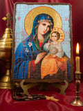 This Eastern Orthodox wooden icon is a beautiful depiction of the "Unfading Flower" , also known as the Unfading Bloom or Fragrant Flower,  representation of the Virgin Mary Theotokos and the Christ Child. She is portrayed looking tenderly out at the viewer while wearing her traditional deep blue maphorion, lined with vibrant green and decorated with fine gold patterns. In her right hand, she gently cradles a stalk of white lilies. 