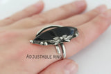 One of a kind Silver ring with black stone on a hand, labeled 'Adjustable Ring'.
