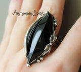 Black stone one of a kind ring with silver setting on a hand, brand 'Armenian Spirit' visible