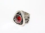 Silver ring with a red gemstone on a white background