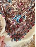 Close-up of a intricately designed scarf with floral pale blue and pink patterns.
