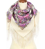 Floral patterned milky white scarf with fringes and purple and pink vintage peony with fringes on a mannequin against a white background