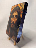 Close-up of a 13x17 cm sacred wood plaque icon of Jesus Christ for desktop or nightstand display. Handmade Christian religious gift showing the face of Jesus in warm golden and amber tones.