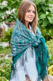 Woman wearing a green patterned scarf in a garden setting