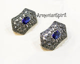 A pair of silver earrings featuring blue marcasite stones, set against a white background.