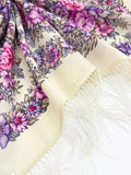Floral patterned merino wool shawl with white fringe on a white background