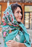 Woman wearing a floral mint green merino wool headscarf with pink vintage peony and lily flowers.