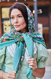 Woman wearing a floral woolen mint headscarf and green dress in an outdoor setting