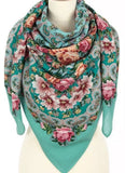 Colorful green and pink peony and lily flowers patterned merino wool scarf on a mannequin against a white background