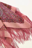 Pink woolen scarf with intricate paisley patterns and fringes on a white background