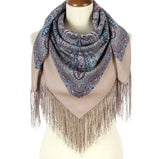 Scarf  made of organic wool with paisley pattern and fringe wrapped on a mannequin against a white background