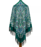 Green paisley patterned woolen shawl with fringes on a white background