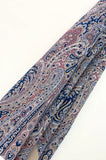 Close-up of a patterned shawl with blue, red, and beige colors on a white background