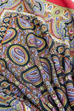 Colorful paisley patterned shawl on a red background