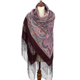 Paisley patterned purple merino wool large scarf with fringes on a mannequin against a white background