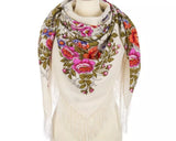 Floral patterned wrapping palatine scarf made of merino wool with fringes on a mannequin against a white background