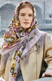 Woman wearing a floral purple headscarf with a blurred architectural background