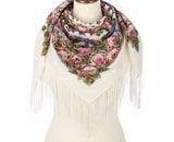 Floral patterned white Slavic scarf with fringes made of merino wool on a mannequin against a white background