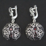 A pair of sterling silver 925 earrings with pomegranate-shaped dangle and natural faceted garnet stones.