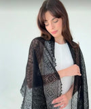 A person wearing a rectangle black pashmina premium quality shawl draped elegantly over the shoulders, displaying its ultra-thin and lightweight sheer drape.