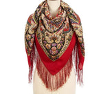 Colorful patterned scarf with fringes on a mannequin against a white background
